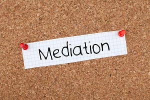 Image of the word Mediation on a note pinned to a bulletin board.